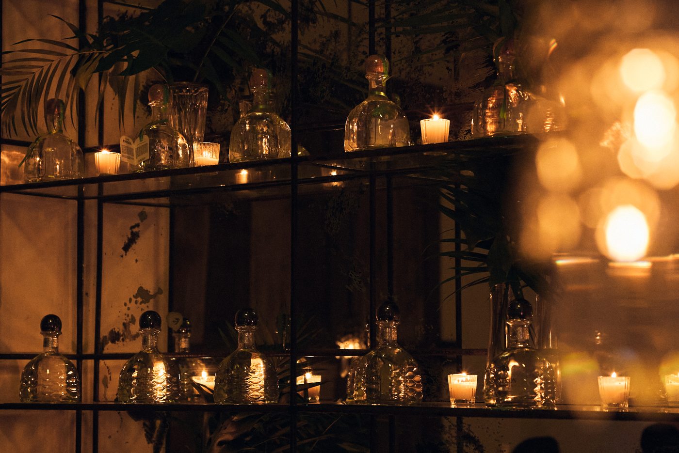 Patrón bottles and candles on the bar shelving