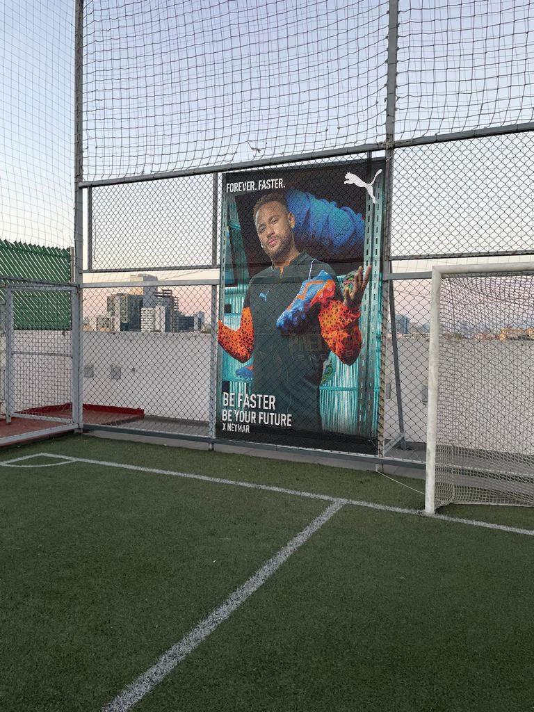Neymar poster installed on the venue fence at dusk